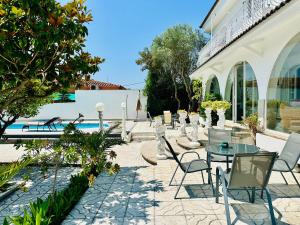 a patio with chairs and tables and a pool at Global Immo 8010 Montclar in Roses