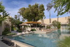 a swimming pool with chairs and umbrellas at Eden Resort & Villas Phuket Patong in Patong Beach
