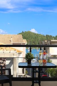 a table with two bottles and glasses on a balcony at NS Apartments Nydri in Nydri