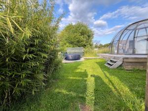 a garden with a greenhouse and a green yard at La bulle de Mont in Yvoir +12 photos