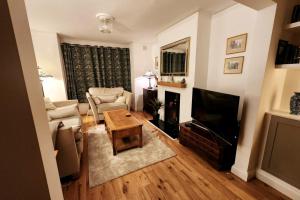a living room with a couch and a television at Stylish Poole Stay: 2BD Victorian Home in Parkstone +10 photos