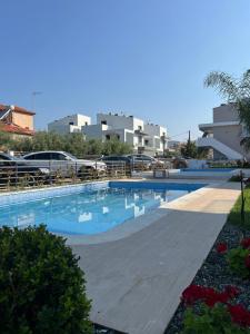 a swimming pool in front of a building at Blue Breeze Apart-Danai B in Ofrínion