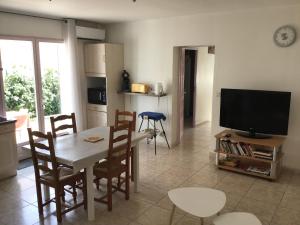 salon ze stołem i telewizorem w obiekcie Appartement avec extérieur et parking gratuit w Perpignanie
