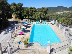 a large swimming pool with lounge chairs at La Villa Nais PADEL&PISCINE -Suites & Appartements in Bormes-les-Mimosas