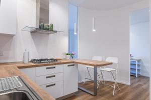 a kitchen with white cabinets and a table with chairs at Blu - La Casa sul Mare in Lido di Ostia