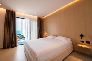 a bedroom with a large bed with a view of the ocean at Austin Boutique Hotel in Sarandë