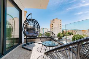 a balcony with two chairs and a swing at Austin Boutique Hotel in Sarandë