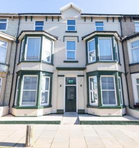 a large white house with green windows and a door at Charles Alexander Short Stay - TheWestern Blackpool in Blackpool