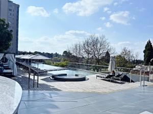 a person sitting in a chair on a patio at Stunning City View Apartment Sandton City in Johannesburg