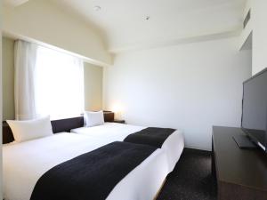 Postel nebo postele na pokoji v ubytování APA Hotel Sagamihara Hashimoto Ekimae