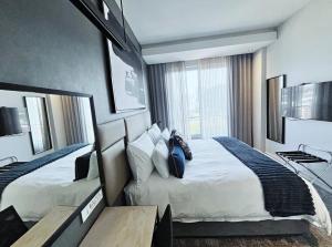 a hotel room with two beds and a desk at Stunning City View Apartment Sandton City in Johannesburg +23 photos