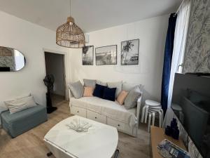 un salon avec un canapé et une table dans l'établissement Cosy cottage by Alice Les bords de mer Turquoise, à La Ciotat