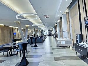 a lobby with tables and chairs in a building at Stunning City View Apartment Sandton City in Johannesburg