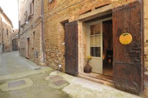 an alley with an open door and a building at La Casina Del Lillotatini in Panicale
