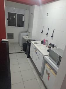 a small white kitchen with a sink and a microwave at Apto novíssimo prox Alphaville e ginásio barueri in Jandira +12 photos
