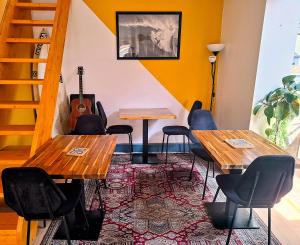 a room with two tables and chairs and a guitar at Le Surf Spot Capbreton in Capbreton +7 photos