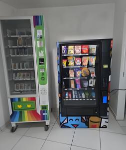 a refrigerator with its door open next to a shelf at Residencial Tia Antonia in Curitiba