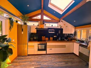 a kitchen with white cabinets and a blue ceiling at Le Surf Spot Capbreton in Capbreton