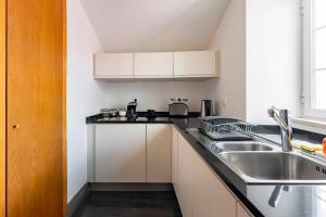 una cucina con un lavello e un piano di lavoro di Tower of Belém Premium Apartments A, B & C a Lisbona Altre 53 foto
