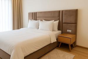 a bedroom with a large bed and a night stand at New studio - Maarif Casablanca in Casablanca