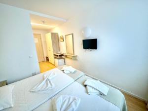 ein Schlafzimmer mit zwei Betten und einem Fernseher an der Wand in der Unterkunft Hotel Diana in Eforie Nord
