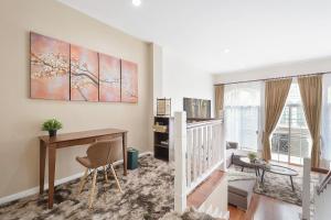 a living room with a staircase and a desk at Stylish 3BR Townhouse Near Rama9 in Sathani Ban Hua Mak