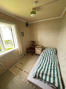 a bedroom with a bed and a window and a chair at Retro hus med fin beliggenhet in Haddal