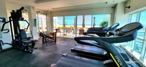een fitnessruimte met cardio-apparatuur en uitzicht op het strand bij Sofisticado Flat em Brasília-BR in Brasilia