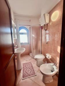 a bathroom with a toilet sink and a shower at Villetta Anna in Golfo Aranci +18 photos