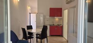 a small kitchen with a table and chairs in a room at APARTMENTS BRUNO 3 - two-room penthouse apartment - wonderful view of the sea - the best location, first row to the beach - 10 minutes from Supetar ferry port - free secured parking - facilities nearby in Sutivan