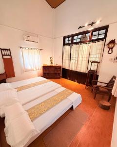 a bedroom with two beds and a chair at Ananda Home in Tân Hiệp