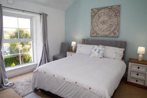 a bedroom with a white bed and a window at Sea Salt Tenby in Tenby