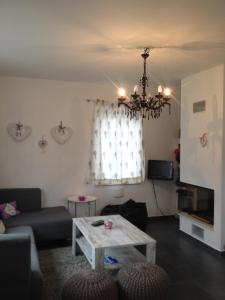 a living room with a couch and a chandelier at Dům na Lipně in Lipno nad Vltavou