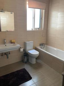 Un baño con inodoro, bañera y lavabo. en Spacious Apartment in Downtown City, en Il-Gżira