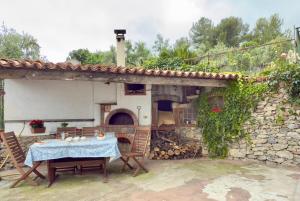 a table and chairs in front of a stone building at Dimora Concept - Ca' du Dria - Sea and nature - Free parking in Pietra Ligure