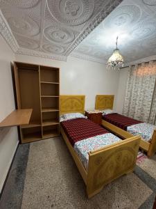 a bedroom with two beds and a coffered ceiling at Appartement Atlas, Rue Mouatamid Ibn Abbad, Immeuble Malki, 1er étage, Oujda in Oujda