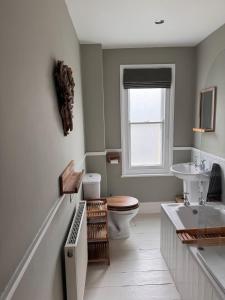 a bathroom with a sink and a toilet and a window at Saviours View in Dartmouth +32 photos