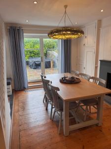 a dining room table with chairs and a chandelier at Saviours View in Dartmouth