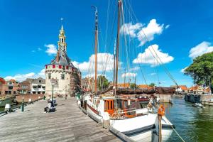 a boat is docked at a dock with a tower at Het Haven Huysje in Hoorn