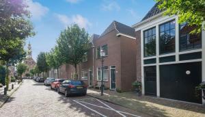 a street with cars parked in front of buildings at Het Haven Huysje in Hoorn
