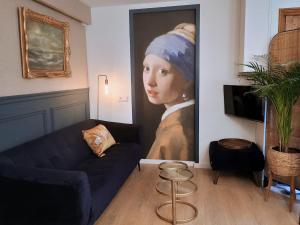 a living room with a painting of a woman with a head at Het Haven Huysje in Hoorn