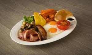 a plate of breakfast food with eggs meat and vegetables at Miami Apartments in St. Julianʼs