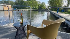 a table and chairs and a bottle of wine on a boat at Houseboat 18 Nordic in Offingawier