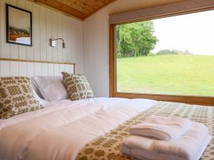 a bed in a room with a large window at Defaid Cymreig in Oswestry