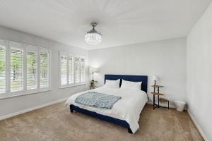 Dormitorio blanco con cama azul y ventanas en Poolhouse in the Pines, en Colorado Springs 23 fotos más