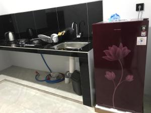 une petite cuisine avec un évier et un comptoir avec une fleur peinte dessus dans l'établissement Rumah Asri Devarastra #1, à Amed