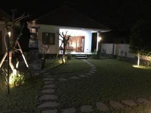 - un jardin la nuit avec une maison éclairée dans l'établissement Rumah Asri Devarastra #1, à Amed 3 autres photos