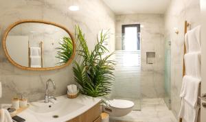 a bathroom with a sink and a toilet and a mirror at טל תאי בוטיק - Tal Thai Boutique in Shelomi