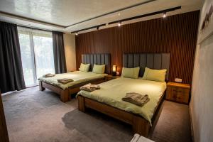 Una habitación de hotel con dos camas y una ventana. en Комплекс язовир Валтата Komplex yazovir VALTATA, en Samuilovo 186 fotos más