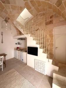 a living room with a staircase and a tv at Dimora Orsini del Balzo in Carovigno